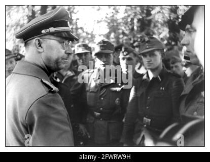 HIMMLER 1940's WW2 Heinrich Luitpold Himmler in conversation with soldiers of the Waffen SS  he was Reichsführer of the Schutzstaffel (Protection Squadron; SS), and a leading member of the Nazi Party (NSDAP) of Germany. Himmler was one of the most powerful men in Nazi Germany and a main architect of the Holocaust. Stock Photo
