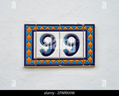 Street sign number 99 on a white wall Stock Photo - Alamy