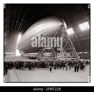 GRAF ZEPPELIN 1930’s Guests watch as the Graf Zeppelin moored in a large hangar at Akron, Ohio USA is prepared for its return air trip to Europe Oct. 27, 1933. Graf Zeppelin provided a commercial passenger and mail service between Germany and Brazil via USA for five years. When the Nazi Party came to power, they used it as a propaganda tool. It was withdrawn from service after the Hindenburg disaster in 1937, and scrapped for military aircraft production in 1940. Stock Photo