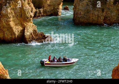 Tourists enjoying the view of the spectacular rock formations from a boat Stock Photo