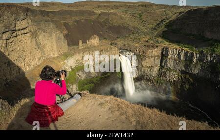 Girl taking photo of Palouse Falls in Washington State Park Stock Photo