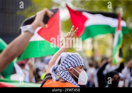 Berlin, Germany. 24th May, 2021. A man makes the Victory sign at a rally titled 'Solidarity with Gaza, Jerusalem and Sheikh Al Jarrah' at Breitscheidplatz. Credit: Christoph Soeder/dpa/Alamy Live News Stock Photo