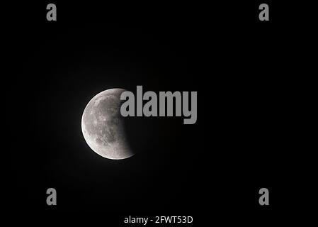 Partial lunar eclipse over the dark sky Stock Photo