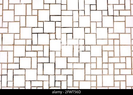 Background from a wall made of square and rectangular white mosaic tiles Stock Photo