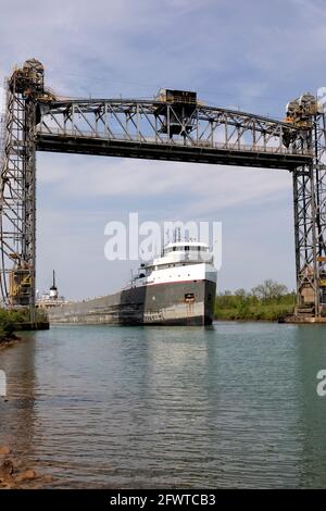 The Ojibway freight ship passing under bridge 5, also known as the Glendale Bridge, a vertical lift bridge the Welland Canal in St. Catharines, Ontari Stock Photo