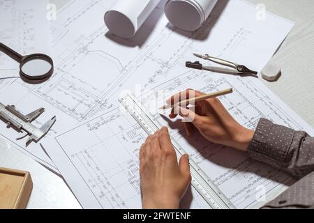 The hands of the architect draw sketches and blueprints on the desktop. Stock Photo