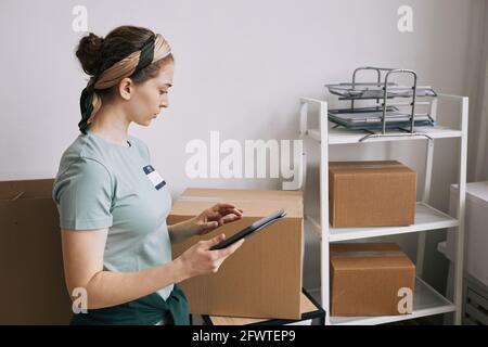 Young female volunteer holding recycle bin with garbage on green ...