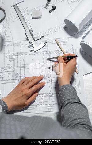 The architect measures with a dividers for drawing on paper. The designer draws a sketch of the project of the room. Stock Photo