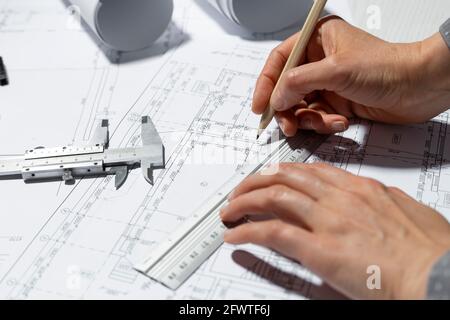 The hands of the architect draw sketches and blueprints on the desktop. Stock Photo