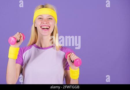 Ultimate upper body workout for women. Girl hold dumbbells wear bright wristbands. Vintage sport concept. Woman exercising with dumbbells. Easy Stock Photo