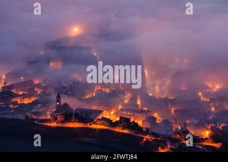 Berga city among fog, in the morning twilight - blue hour, seen from the Figuerassa viewpoint (Berguedà, Barcelona, Catalonia, Spain, Pyrenees) Stock Photo