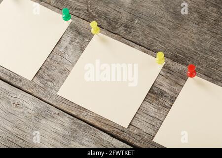 Sticky notes with pins in a row on a wooden background. Space for text, free space, top view Stock Photo