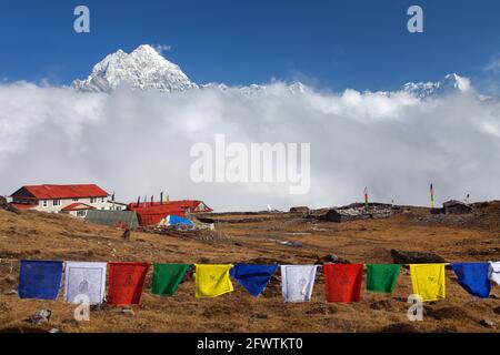 View of mount Thamserku, Kongde village and prayer flags, Khumbu valley, Solukhumbu, Nepal Himalayas Stock Photo