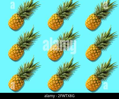Fruit pattern with fresh organic pineapples with hard shadows on bright azure background. Top view, flat lay, minimalist design. Stock Photo