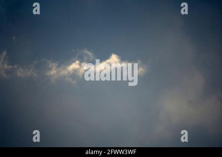 Small white fluffy cloud in a blue winter sky, Lancashire, UK Stock Photo