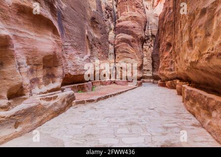 The Siq, narrow gorge, main entrance to the ancient city Petra, Jordan Stock Photo