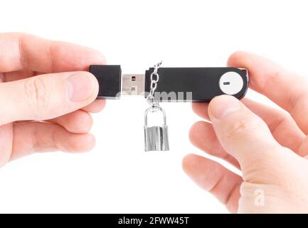 Close-up of male hands holding a memory stick with a small padlock on a chain isolated on white. Flash drive data protection concept. Stock Photo