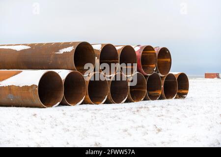 Large tubes in winter tundra. Construction Marine offshore works. Dam building. Stock Photo