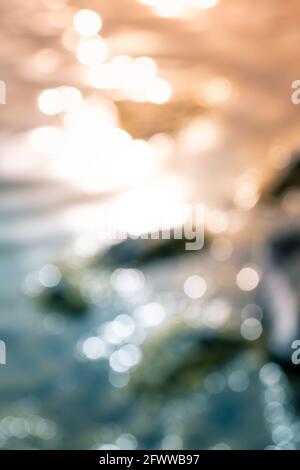 Bokeh shapes and shadows on water surfaces on the coast creating texture and patterned backgrounds and backdrops. Stock Photo