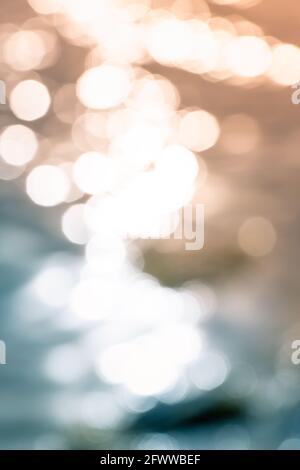 Bokeh shapes and shadows on water surfaces on the coast creating texture and patterned backgrounds and backdrops. Stock Photo