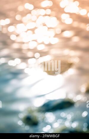 Bokeh shapes and shadows on water surfaces on the coast creating texture and patterned backgrounds and backdrops. Stock Photo