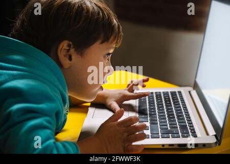Little boy looking in amazement at a laptop. Stock Photo