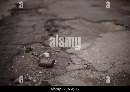 Closeup view of an old broken asphalt road. Stock Photo