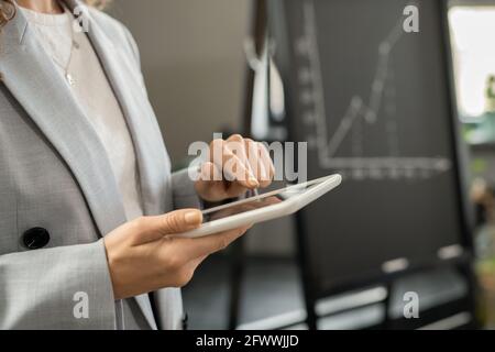 Young businesswoman in formalwear pointing at screen of tablet Stock Photo