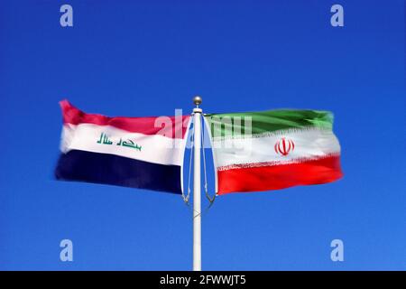 Iraqi and Iranian flags wave side-by-side in opposing winds on a single flagpole. Digital composite. Stock Photo