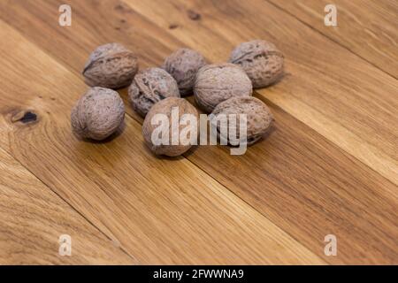Ripe walnuts on wooden rustic backdrop. Healthy nut food for brain. Fresh walnuts background concept Stock Photo