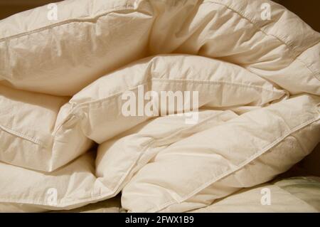 Soft folded white blanket close up on a bed at home Stock Photo