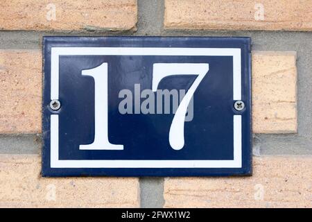 Number 17 in white on a blue metal plate Stock Photo