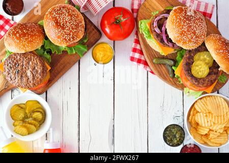 BBQ hamburger frame. Top view table scene over a white wood background. Copy space. Stock Photo