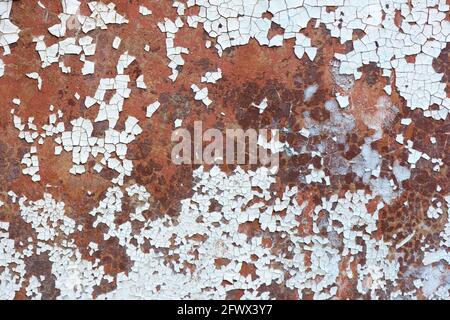 white pain peeling off a rusty metal surface – a texture Stock Photo
