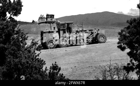 Road construction workers use a Caterpillar motor grader and Komatsu bulldozer to move dirt at a road improvement job site in Santa Fe, New Mexico. Stock Photo