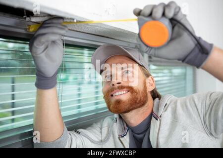 man installing cassette roller blinds on windows Stock Photo