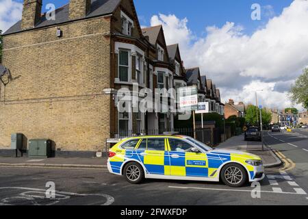 Marked police car stops at give way junction at Charlton, South London Stock Photo