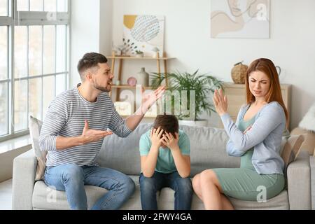 Sad little boy and his quarrelling parents at home Stock Photo