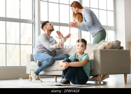 Sad little boy and his quarrelling parents at home Stock Photo