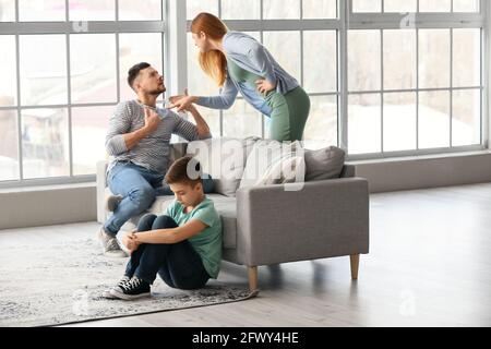 Sad little boy and his quarrelling parents at home Stock Photo