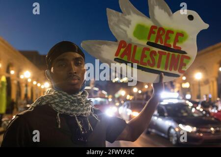 Columbus, United States. 21st May, 2021. A man holds a Free Palestine placard at the intersection of North High St. and Goodale St.Demonstrators gathered at Goodale Park in Columbus, Ohio to rally and march against Israel's occupation of Palestine. The demonstrators marched from Goodale Park up and down North High St. for hours, clogging some of the main roads until the demonstrators made their way back to Goodale Park for a candle light vigil for those who have died during the occupation of Israel. Credit: SOPA Images Limited/Alamy Live News Stock Photo