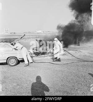 Rescue demonstration at circuit of Zandvoort, volunteers with equipped BMW extinguish fires from wreck, 9 April 1974, VOLUNTEERS, demonstrations, The Netherlands, 20th century press agency photo, news to remember, documentary, historic photography 1945-1990, visual stories, human history of the Twentieth Century, capturing moments in time Stock Photo