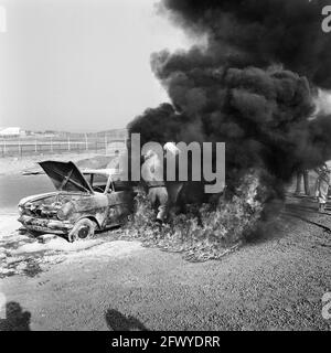 Rescue demonstration on circuit of Zandvoort, volunteers with BMW extinguish burning wreck, 9 April 1974, VOLUNTEERS, demonstrations, The Netherlands, 20th century press agency photo, news to remember, documentary, historic photography 1945-1990, visual stories, human history of the Twentieth Century, capturing moments in time Stock Photo