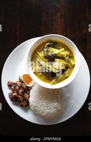 Authentic thai sour curry with fish with rice and salted egg fried pork meal set on table Stock Photo