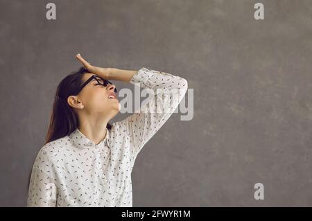 Young caucasian woman touching forehead regrets wrong doing studio shot Stock Photo