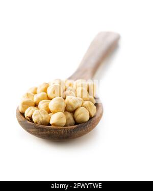 Peeled roasted hazelnuts in wooden spoon isolated on white background. Stock Photo