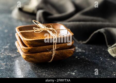 Three empty wooden bowl on black table. Stock Photo