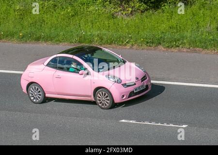 2006 pink Nissan Micra Sport C+C; Vehicular traffic, moving vehicles, cars, vehicle driving on UK roads, motors, motoring on the M6 motorway highway UK road network. Stock Photo