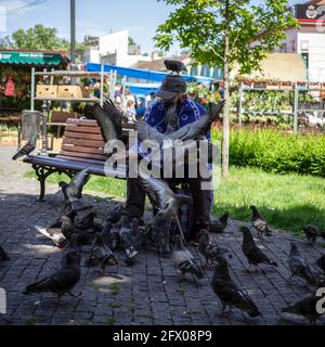 Belgrade, Serbia, May 23, 2021: Senior citizen feeding pigeons in the park Stock Photo