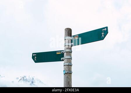 Low angle of direction pole with simple boards showing directions of footpaths for hikers in Peaks of Europe Stock Photo
